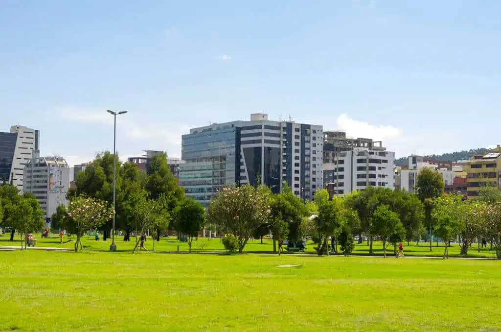 Interior del parque de La Carolina en Quito, Ecuador. Hermosos exteriores verdes con algunos altos edificios de oficinas que marcan la presencia de la ciudad